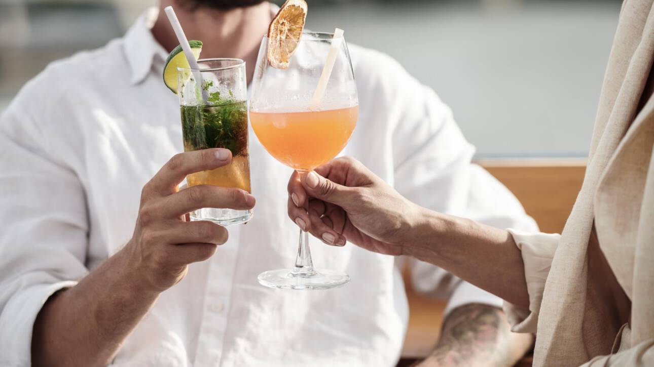 Cropped image of couple drinking fruit cocktails at outdoor party